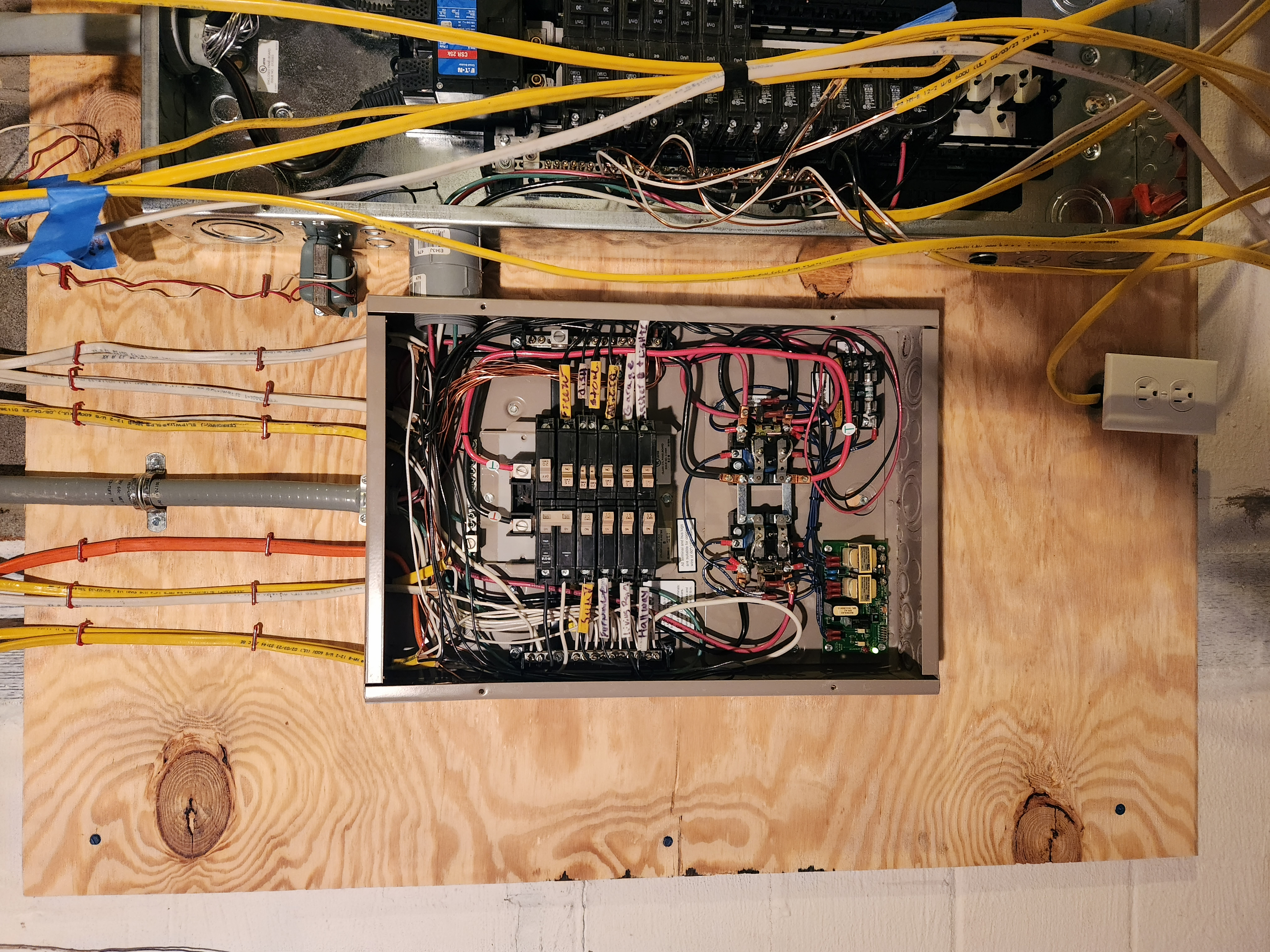 Open electrical boxes mounted on a building exterior, revealing wiring and components