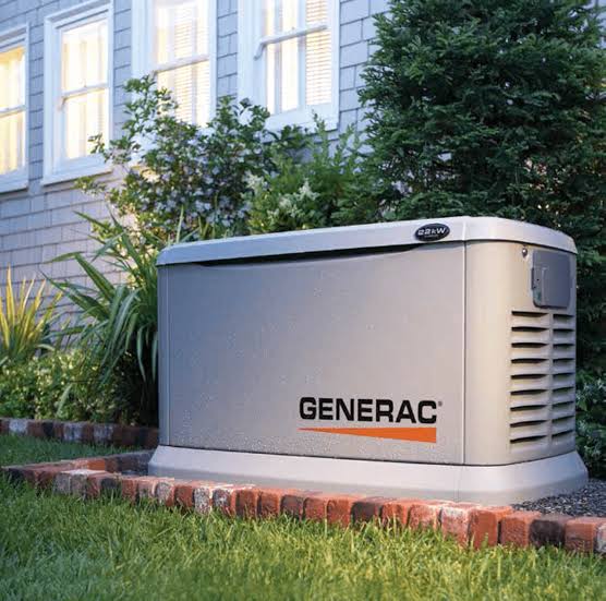 Generators and air conditioners on a concrete pad next to a building