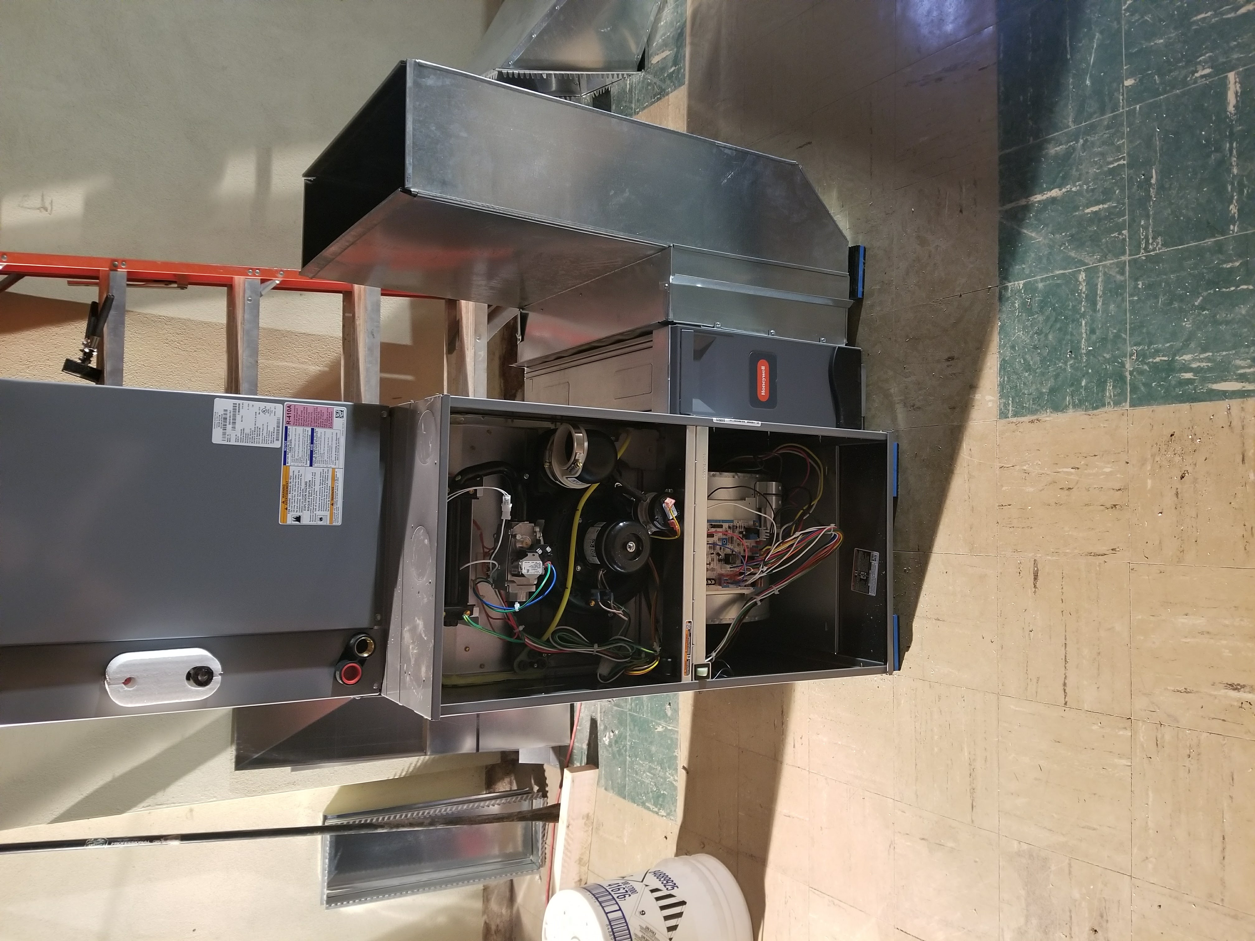 Air conditioning unit being serviced outside a white house, with refrigerant tank and equipment