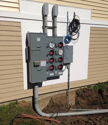 Electrical box with wires connecting to terminals inside a grey enclosure